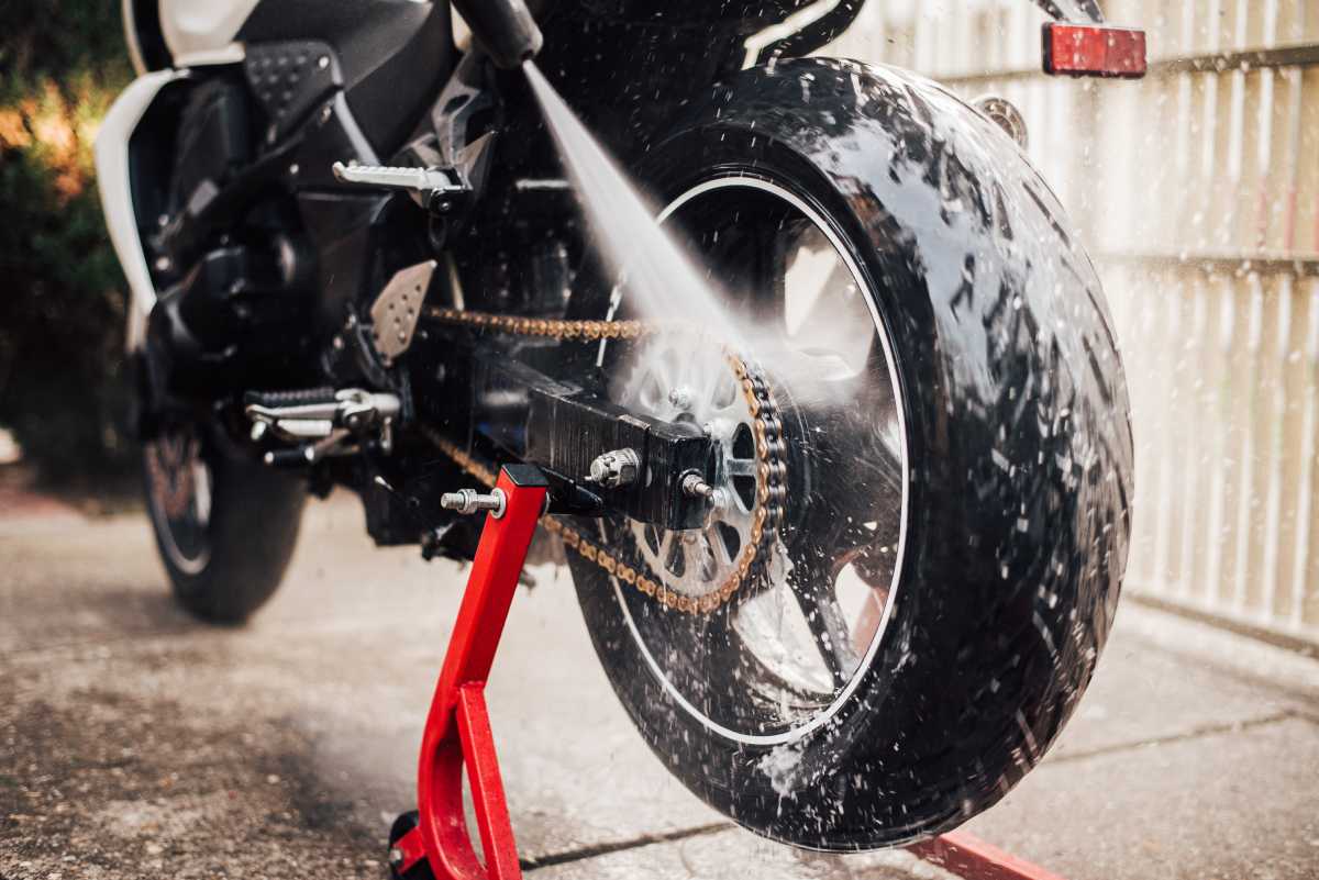 Washing a motorcycle with a high pressure sprayer.