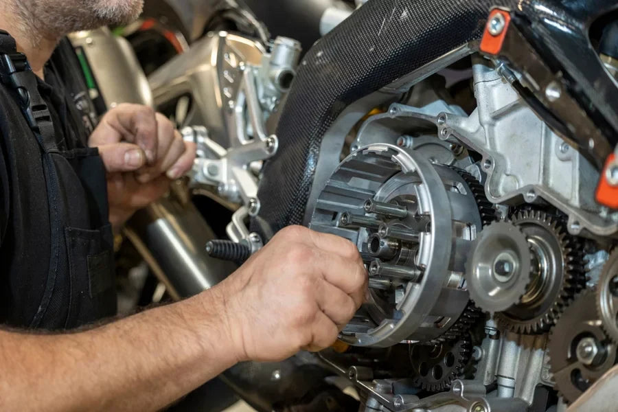 A person repairing a motorcycle engine